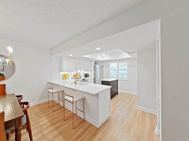 3504 Wedge Way, New Port Richey, FL 34655 - kitchen featuring appliances with stainless steel finishes, light wood-style floors, a center island, light countertops, and a kitchen bar