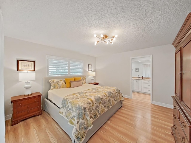 3504 Wedge Way, New Port Richey, FL 34655 - bedroom featuring light wood finished floors, a chandelier, a textured ceiling, and connected bathroom