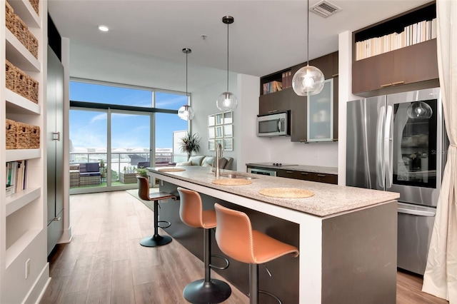 111 N 12th St Unit 1805, Tampa, FL 33602 - kitchen with appliances with stainless steel finishes, a sink, a wall of windows, modern cabinets, and plenty of natural light