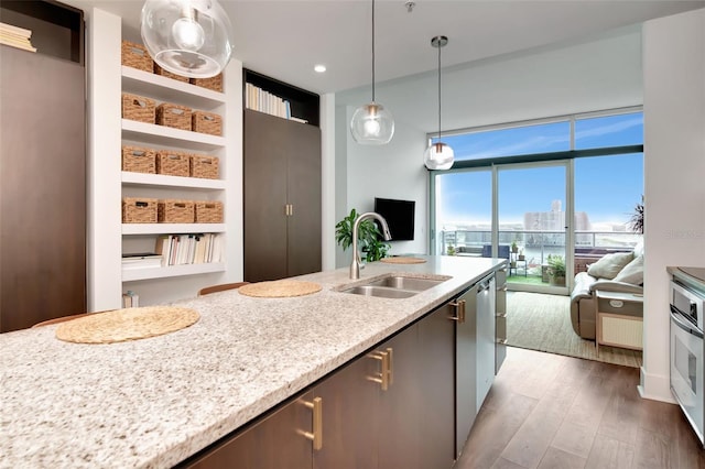 111 N 12th St Unit 1805, Tampa, FL 33602 - kitchen featuring a sink, open floor plan, wood finished floors, hanging light fixtures, and stainless steel oven