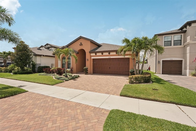 13128 Foxtail Fern Dr, Riverview, FL 33579 - mediterranean / spanish-style house with stucco siding, decorative driveway, a front yard, and a garage