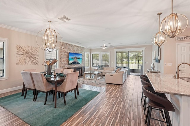 13128 Foxtail Fern Dr, Riverview, FL 33579 - dining area with a chandelier, dark wood-style floors, crown molding, and a large fireplace