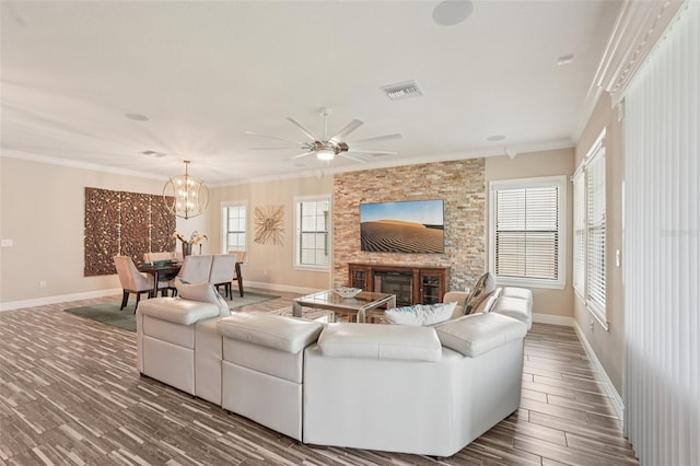 13128 Foxtail Fern Dr, Riverview, FL 33579 - living area with ornamental molding, a stone fireplace, dark wood-style flooring, ceiling fan, and a chandelier