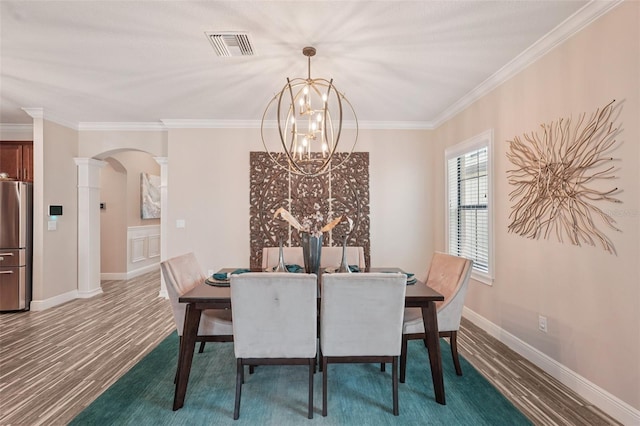13128 Foxtail Fern Dr, Riverview, FL 33579 - dining space with ornate columns, arched walkways, wood finished floors, a chandelier, and crown molding
