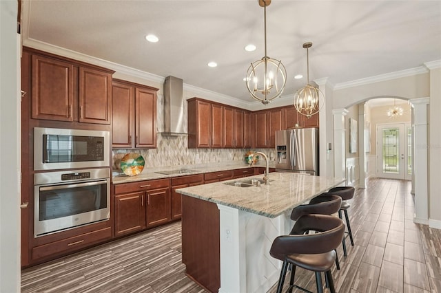 13128 Foxtail Fern Dr, Riverview, FL 33579 - kitchen featuring appliances with stainless steel finishes, wall chimney exhaust hood, arched walkways, a chandelier, and recessed lighting