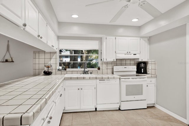 3615 Greatwood Ct, Land O Lakes, FL 34639 - kitchen featuring white appliances, tile countertops, under cabinet range hood, and a sink