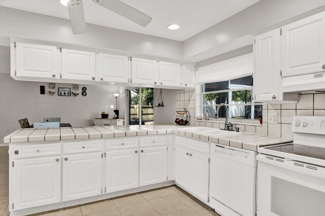 3615 Greatwood Ct, Land O Lakes, FL 34639 - kitchen with white appliances, a sink, a peninsula, custom range hood, and tile countertops
