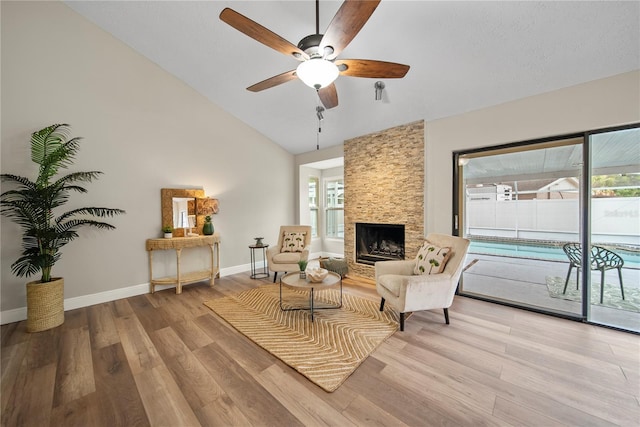 4509 Grainary Ave, Tampa, FL 33624 - sitting room featuring ceiling fan, wood finished floors, baseboards, a stone fireplace, and high vaulted ceiling