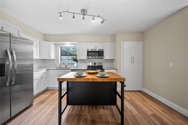 4509 Grainary Ave, Tampa, FL 33624 - kitchen with stainless steel appliances, a sink, tasteful backsplash, and light wood-style floors