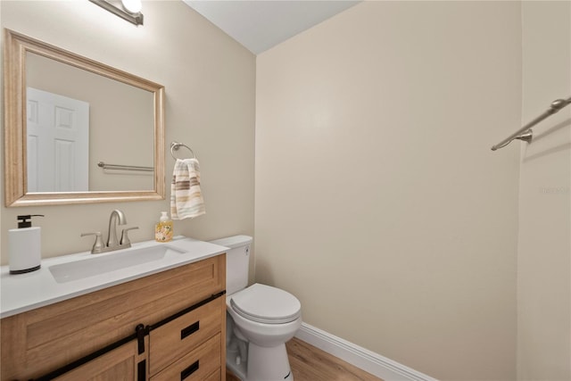 4509 Grainary Ave, Tampa, FL 33624 - half bath featuring toilet, baseboards, vanity, and wood finished floors