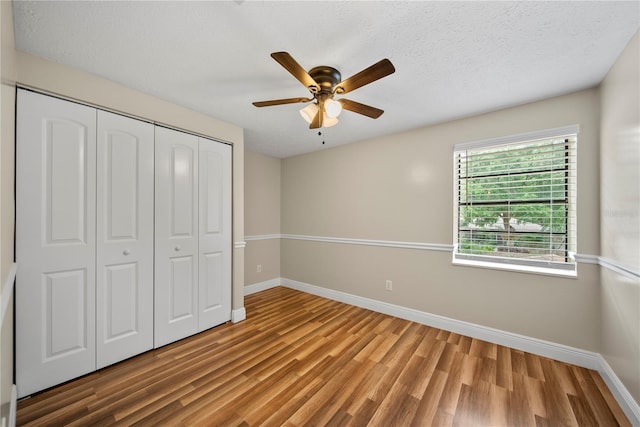 4509 Grainary Ave, Tampa, FL 33624 - unfurnished bedroom featuring baseboards, wood finished floors, a closet, ceiling fan, and a textured ceiling
