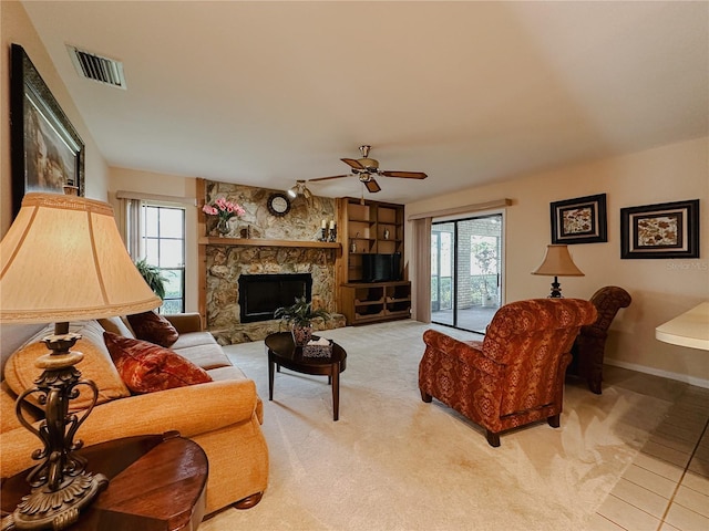 5004 Grainary Ave, Tampa, FL 33624 - living area with a ceiling fan, a stone fireplace, baseboards, and light colored carpet
