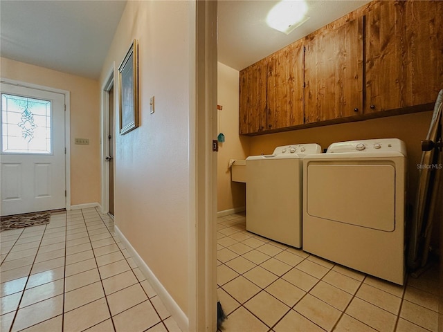 5004 Grainary Ave, Tampa, FL 33624 - laundry area featuring cabinet space, washer and clothes dryer, light tile patterned floors, and baseboards