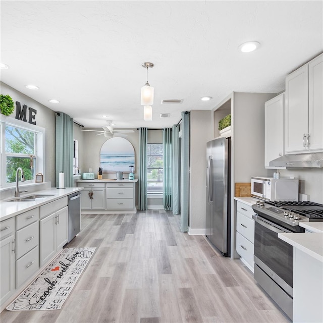 4916 Palmetto Point Dr, Palmetto, FL 34221 - kitchen featuring appliances with stainless steel finishes, a sink, under cabinet range hood, light countertops, and ceiling fan