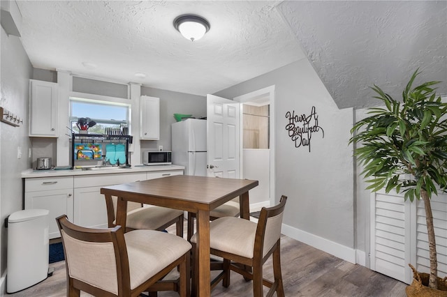 4916 Palmetto Point Dr, Palmetto, FL 34221 - dining space featuring a textured ceiling, light wood finished floors, and baseboards
