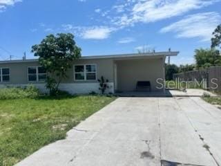 3074 NE Garden Ter, Palm Bay, FL 32905 - ranch-style house featuring driveway, a front yard, and a carport