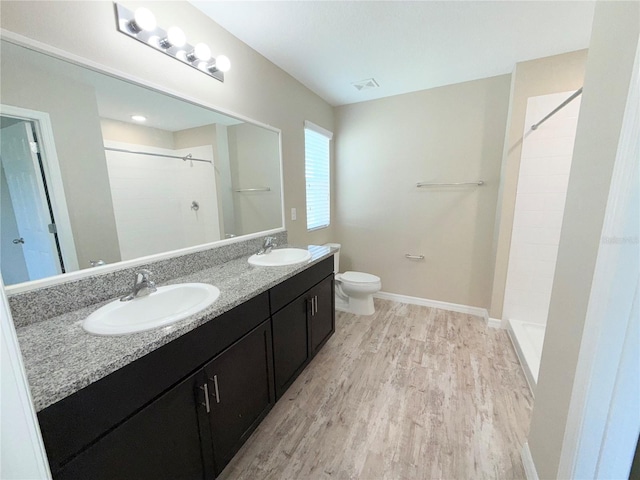 13118 Zolo Springs Cir, Riverview, FL 33579 - full bath with double vanity, a tile shower, wood finished floors, toilet, and baseboards