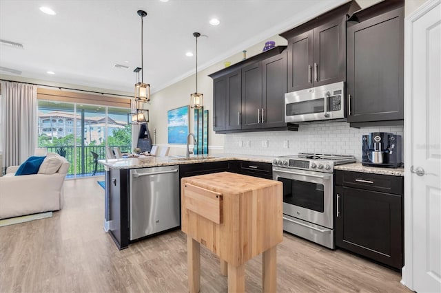 204 Haven Beach Ct, Indian Rocks Beach, FL 33785 - kitchen with appliances with stainless steel finishes, a peninsula, crown molding, backsplash, and light wood-style floors