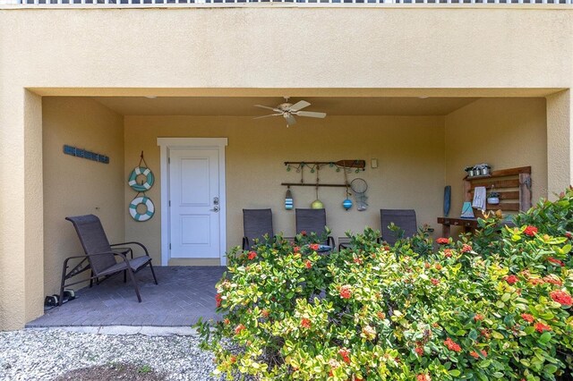 204 Haven Beach Ct, Indian Rocks Beach, FL 33785 - view of exterior entry featuring ceiling fan and stucco siding