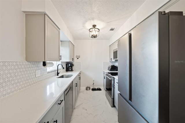 3983 Shay Dr, Bartow, FL 33830 - kitchen featuring appliances with stainless steel finishes, light marble finish floors, backsplash, light countertops, and a textured ceiling