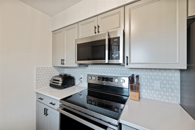 3983 Shay Dr, Bartow, FL 33830 - kitchen with stainless steel appliances, light countertops, tasteful backsplash, and gray cabinetry