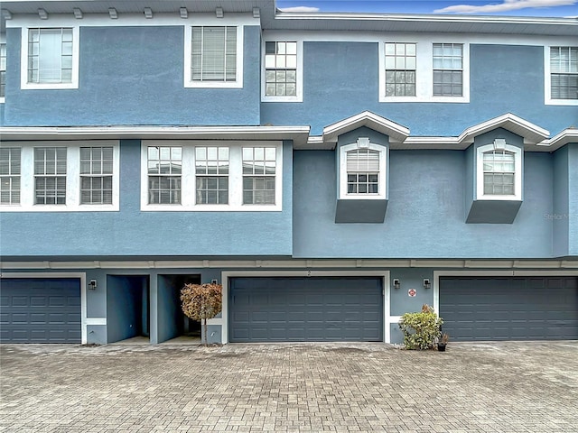 3111 W De Leon St Unit 2, Tampa, FL 33609 - view of property with an attached garage, stucco siding, and driveway