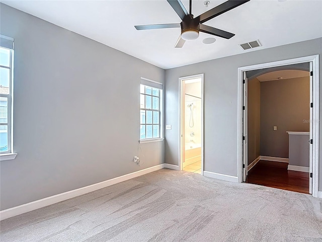 3111 W De Leon St Unit 2, Tampa, FL 33609 - unfurnished bedroom with carpet floors, baseboards, arched walkways, ensuite bathroom, and a ceiling fan