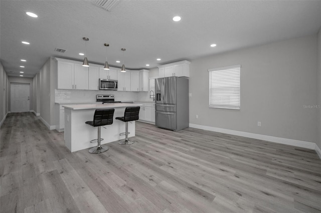 2307 N 47th St, Tampa, FL 33605 - kitchen with appliances with stainless steel finishes, baseboards, light wood-style flooring, light countertops, and recessed lighting