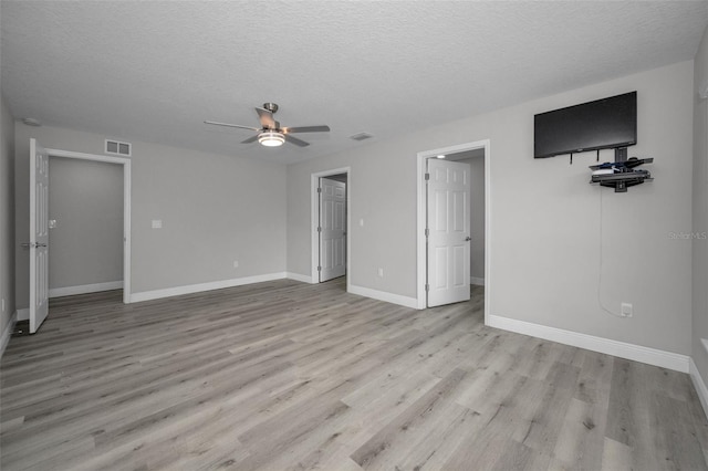 2307 N 47th St, Tampa, FL 33605 - unfurnished living room with ceiling fan, a textured ceiling, light wood-style floors, and baseboards