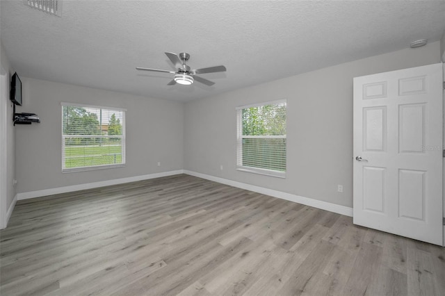 2307 N 47th St, Tampa, FL 33605 - unfurnished room with baseboards, light wood-style flooring, a ceiling fan, and a textured ceiling