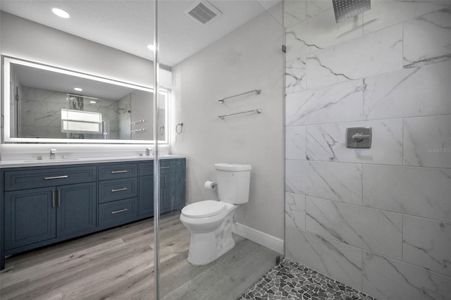 2307 N 47th St, Tampa, FL 33605 - full bath featuring double vanity, toilet, wood finished floors, a marble finish shower, and recessed lighting