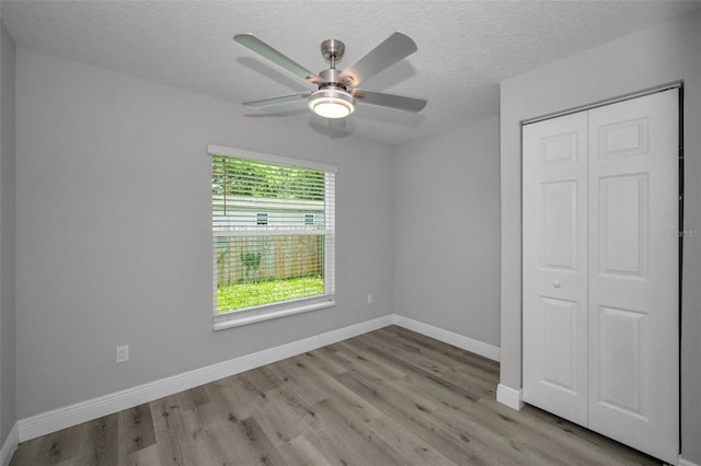 2307 N 47th St, Tampa, FL 33605 - unfurnished bedroom with wood finished floors, a closet, baseboards, a textured ceiling, and ceiling fan
