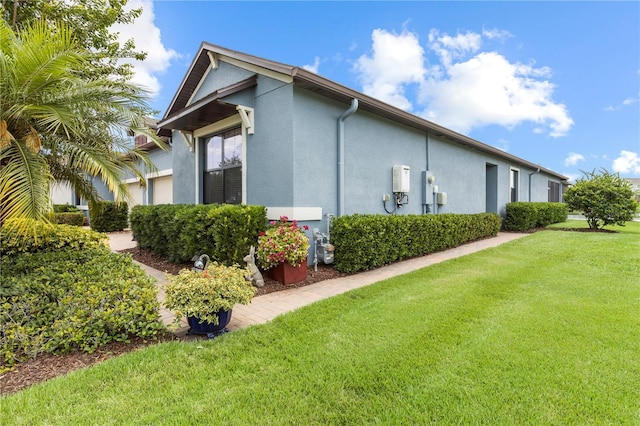 16898 Balance Cv, Land O Lakes, FL 34638 - view of property exterior featuring stucco siding, a yard, and an attached garage