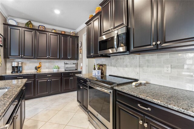 16898 Balance Cv, Land O Lakes, FL 34638 - kitchen with appliances with stainless steel finishes, ornamental molding, tasteful backsplash, dark stone counters, and light tile patterned flooring