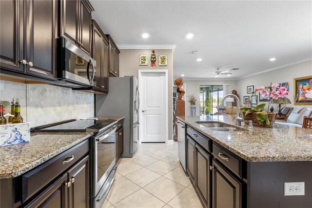 16898 Balance Cv, Land O Lakes, FL 34638 - kitchen with stainless steel appliances, a sink, ornamental molding, tasteful backsplash, and a center island with sink