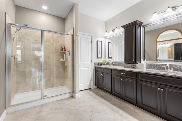 16898 Balance Cv, Land O Lakes, FL 34638 - bathroom with a shower stall, tile patterned flooring, double vanity, and baseboards