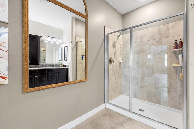 16898 Balance Cv, Land O Lakes, FL 34638 - bathroom with a stall shower, tile patterned flooring, vanity, and baseboards
