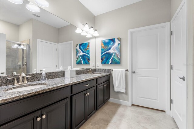 16898 Balance Cv, Land O Lakes, FL 34638 - bathroom with double vanity, a stall shower, tile patterned flooring, and baseboards