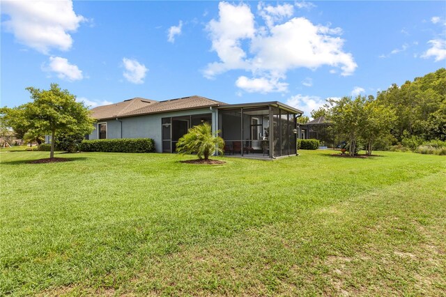 16898 Balance Cv, Land O Lakes, FL 34638 - back of house featuring a sunroom and a yard