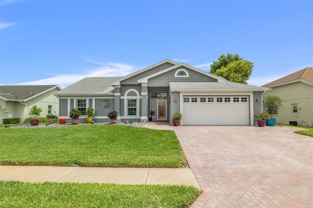 8441 Danbury Ln, Hudson, FL 34667 - single story home with an attached garage, decorative driveway, a front lawn, stucco siding, and roof with shingles