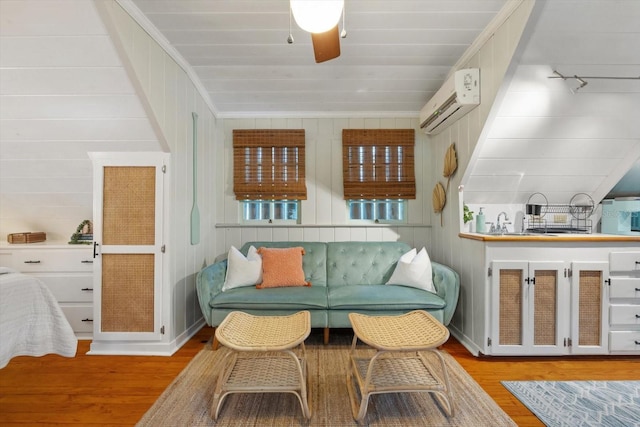 111 29th St W, Bradenton, FL 34205 - sitting room with a wall unit AC, wood finished floors, ceiling fan, and wooden walls