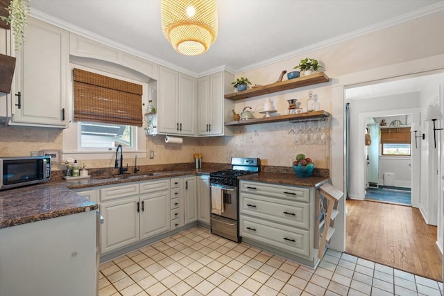 111 29th St W, Bradenton, FL 34205 - kitchen featuring stainless steel appliances, healthy amount of natural light, open shelves, backsplash, and crown molding