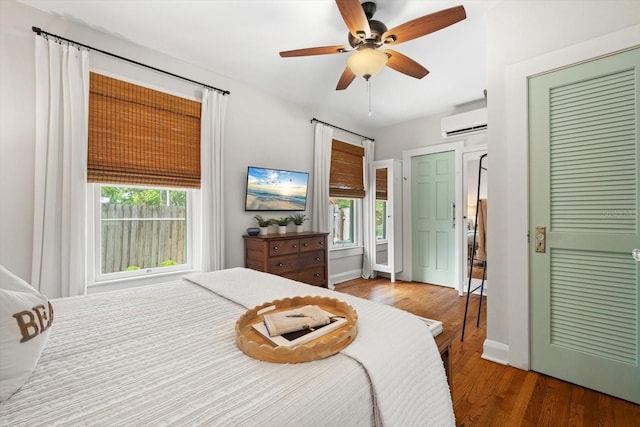 111 29th St W, Bradenton, FL 34205 - bedroom with a wall mounted AC, wood finished floors, and a ceiling fan