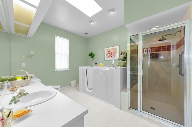 1051 Glynwood Pl, Dunedin, FL 34698 - bathroom featuring a skylight, a garden tub, vanity, a stall shower, and baseboards