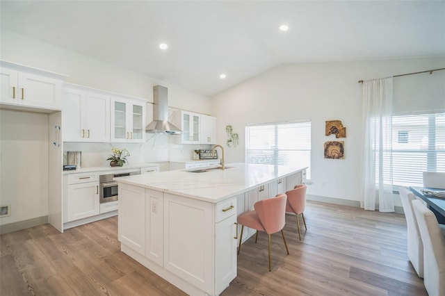 16106 Worlington Pl, Odessa, FL 33556 - kitchen featuring a sink, wall chimney exhaust hood, white cabinetry, glass insert cabinets, and vaulted ceiling