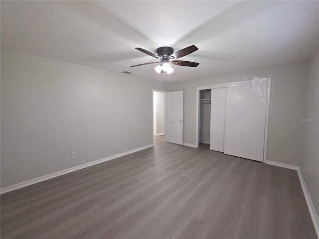 2045 Summit Dr, Dunedin, FL 34698 - unfurnished bedroom with wood finished floors, baseboards, a closet, and a ceiling fan