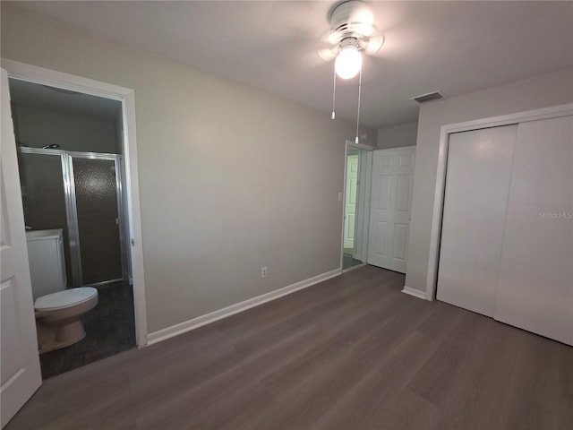 2045 Summit Dr, Dunedin, FL 34698 - unfurnished bedroom featuring wood finished floors, a closet, ensuite bath, and baseboards