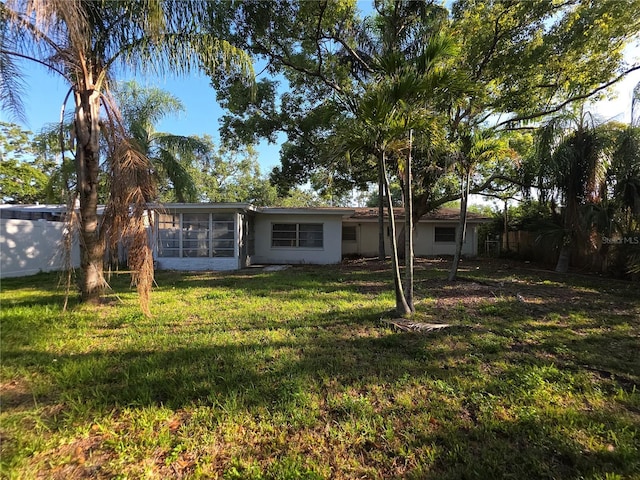 2045 Summit Dr, Dunedin, FL 34698 - rear view of property with a sunroom, a yard, and stucco siding