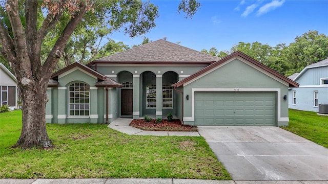 5809 Silas Creek Ln, Wesley Chapel, FL 33545 - view of front of home with stucco siding, a garage, driveway, a front yard, and a shingled roof