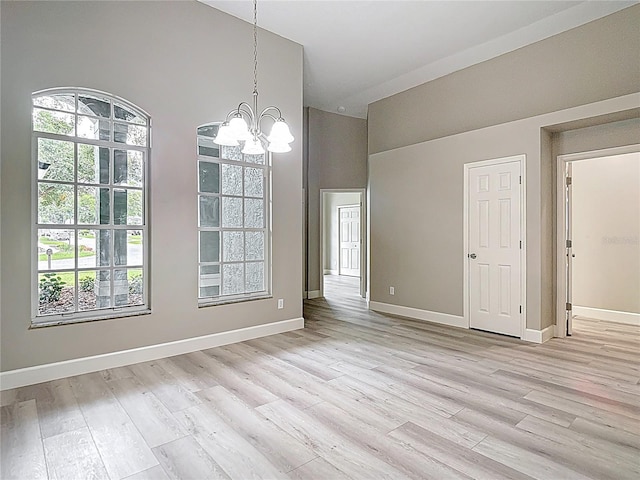 5809 Silas Creek Ln, Wesley Chapel, FL 33545 - unfurnished dining area featuring a chandelier, light wood-type flooring, and a towering ceiling